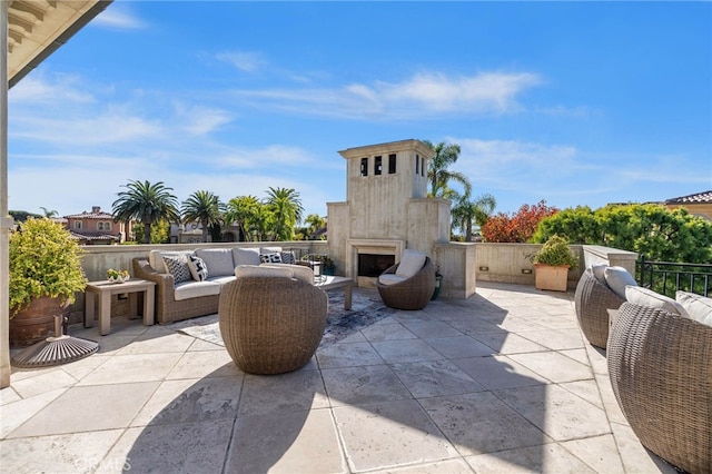 view of patio with an outdoor living space with a fireplace