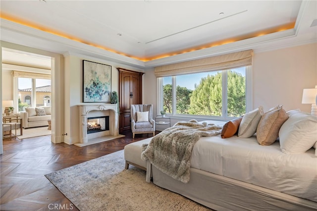 bedroom featuring a raised ceiling, a multi sided fireplace, dark parquet flooring, and multiple windows