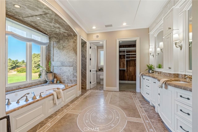 bathroom with vanity, a tub to relax in, toilet, and crown molding