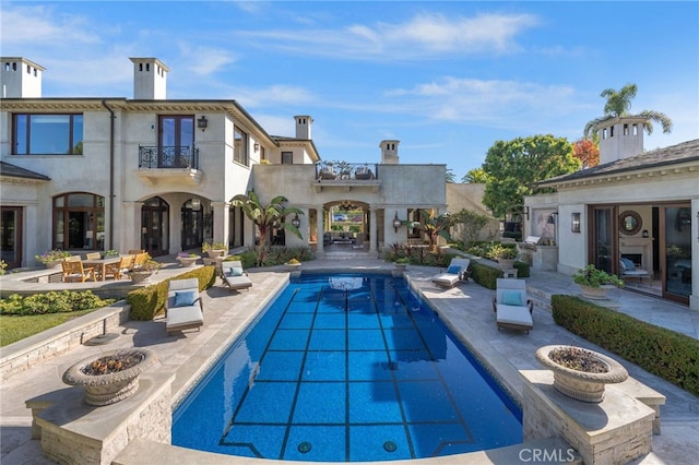 7 Shoreview, Newport Coast, CA 92657 - rear view of property with a balcony, a patio, an outdoor pool, stucco siding, and french doors