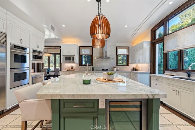 7 Shoreview, Newport Coast, CA 92657 - kitchen with wine cooler, green cabinets, wall chimney range hood, appliances with stainless steel finishes, and white cabinets
