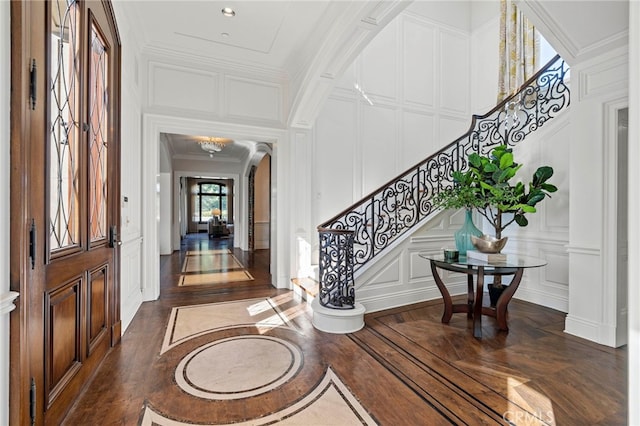7 Shoreview, Newport Coast, CA 92657 - entryway with a decorative wall, crown molding, arched walkways, stairs, and dark wood-style flooring
