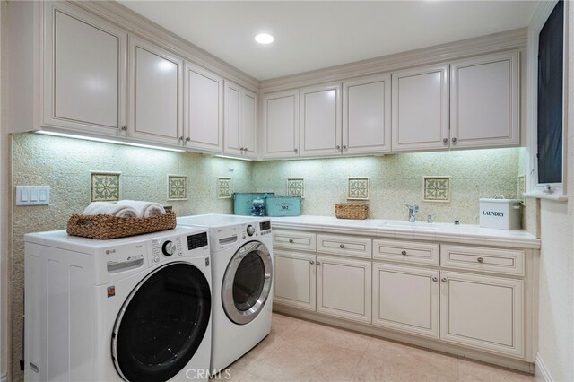 laundry room with washer and dryer, light tile patterned flooring, cabinets, and sink