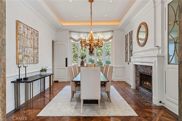 7 Shoreview, Newport Coast, CA 92657 - dining space with a chandelier, a tray ceiling, a premium fireplace, ornamental molding, and a decorative wall