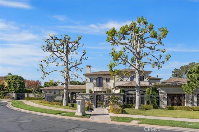 mediterranean / spanish-style home with a balcony and a front lawn