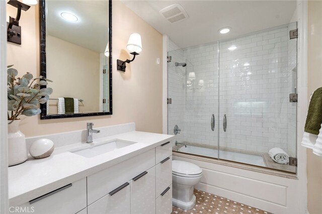 full bathroom with tile patterned floors, vanity, toilet, and shower / bath combination with glass door