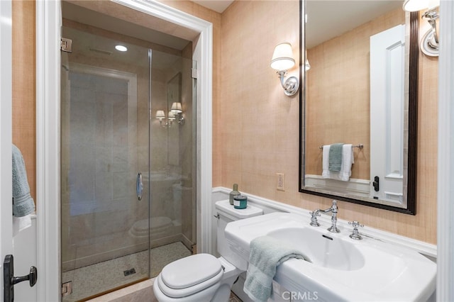 bathroom with toilet and a shower with shower door