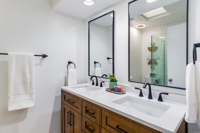 bathroom featuring a skylight, vanity, and walk in shower