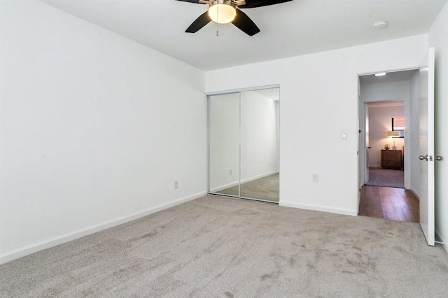 unfurnished bedroom featuring ceiling fan, light carpet, and a closet