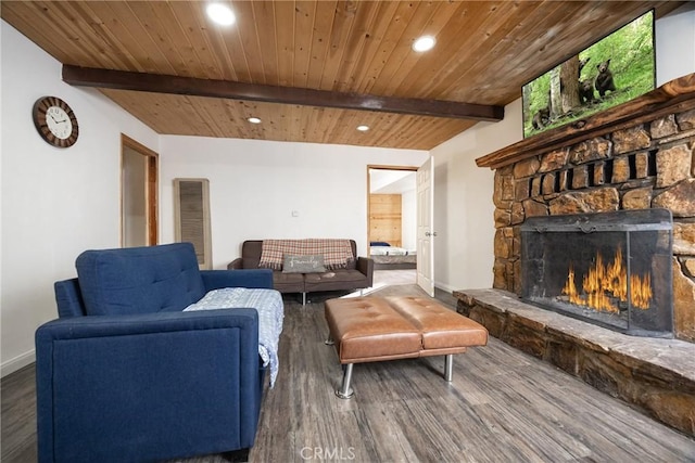 living room featuring beamed ceiling, hardwood / wood-style flooring, a stone fireplace, and wood ceiling