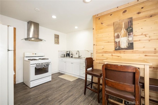 kitchen with wall chimney exhaust hood, white appliances, dark wood-type flooring, sink, and white cabinetry