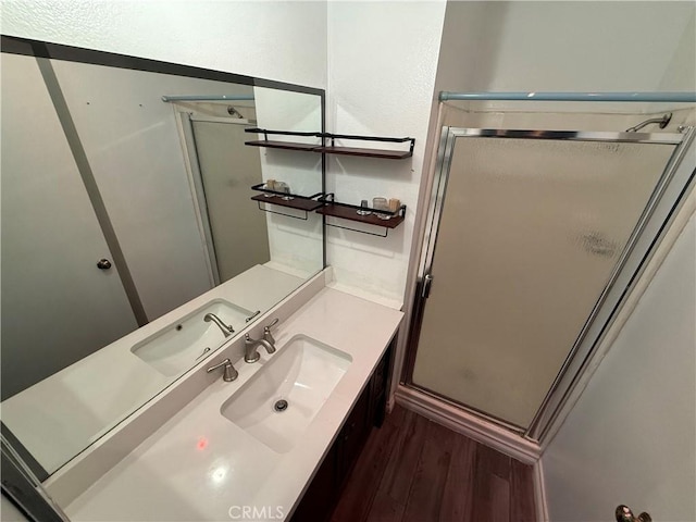 bathroom with vanity, an enclosed shower, and wood-type flooring