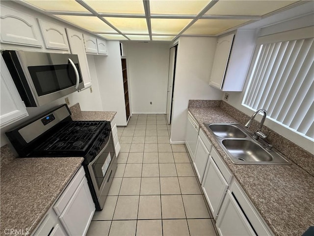 kitchen featuring white cabinets, light tile patterned flooring, sink, and appliances with stainless steel finishes