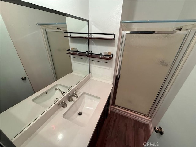 bathroom with hardwood / wood-style floors, vanity, and a shower with shower door