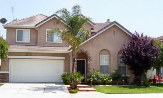 view of property featuring a front yard and a garage