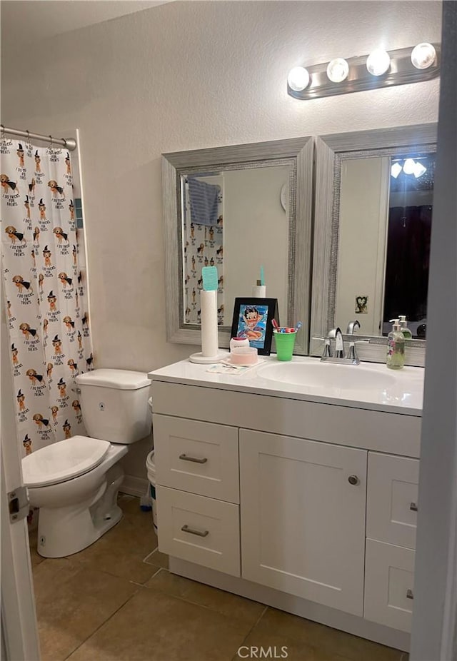 bathroom featuring toilet, vanity, a shower with curtain, and tile patterned floors