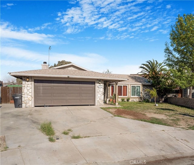 single story home featuring a chimney, an attached garage, fence, stone siding, and driveway