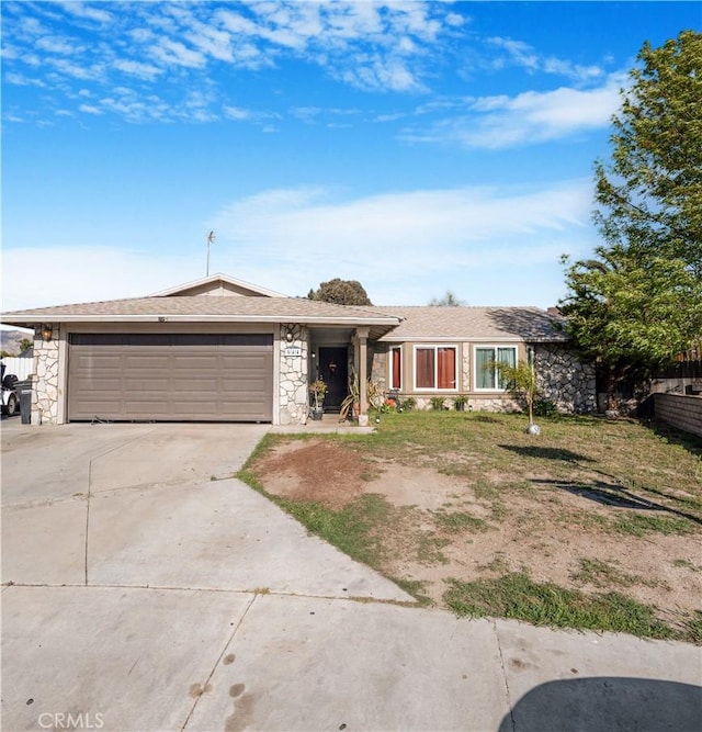 view of front of property featuring stone siding, concrete driveway, and an attached garage