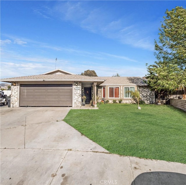 view of front of property with stone siding, a front lawn, an attached garage, and driveway