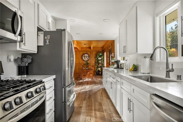 kitchen featuring stainless steel appliances, light countertops, and white cabinets