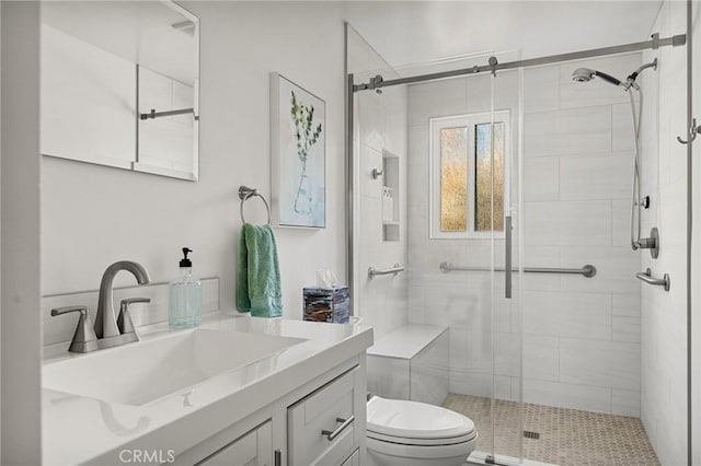 full bathroom with a stall shower, vanity, and toilet