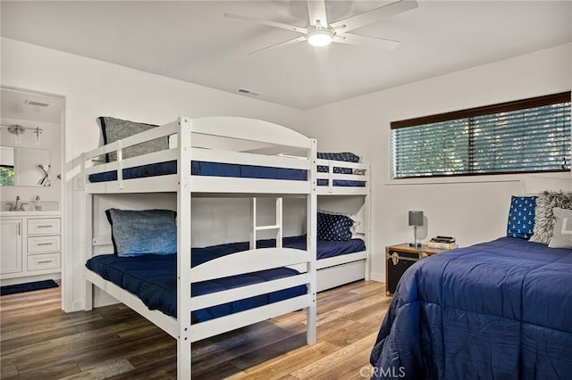 bedroom with visible vents, a sink, and wood finished floors