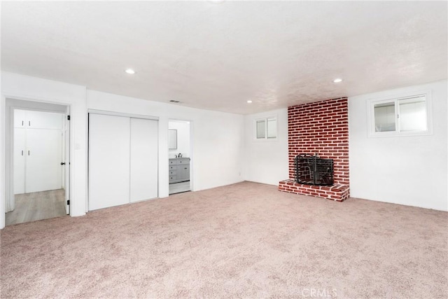 unfurnished living room with carpet floors and a fireplace