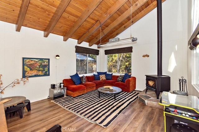 living room featuring beam ceiling, hardwood / wood-style flooring, a wood stove, and wood ceiling