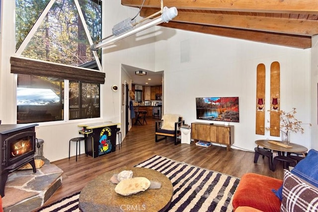 living room with a wood stove, dark hardwood / wood-style flooring, beamed ceiling, and high vaulted ceiling