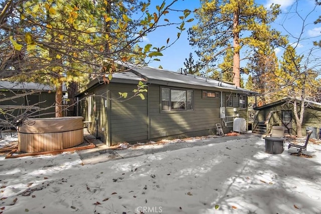 back of property featuring a hot tub