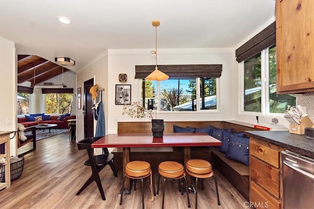 dining area featuring vaulted ceiling with beams, breakfast area, and wood-type flooring