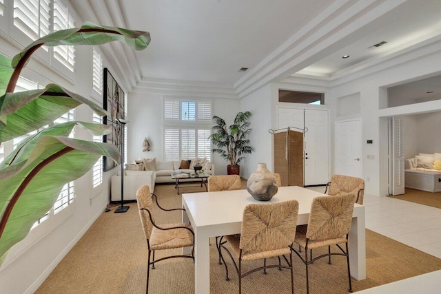 dining area featuring light carpet and a tray ceiling