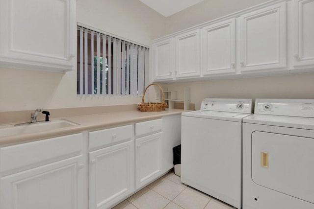 clothes washing area with washer and dryer, light tile patterned floors, sink, and cabinets