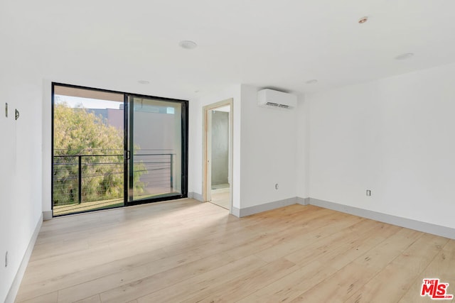 unfurnished room featuring light hardwood / wood-style flooring and a wall unit AC