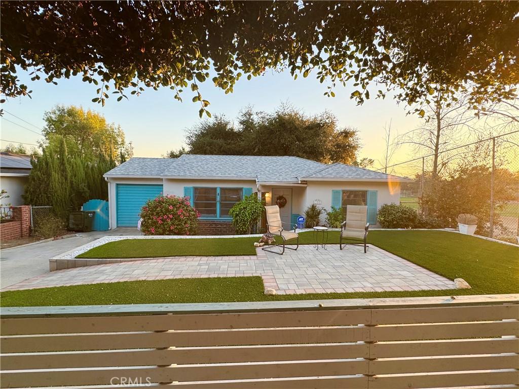 single story home with a patio area and a lawn