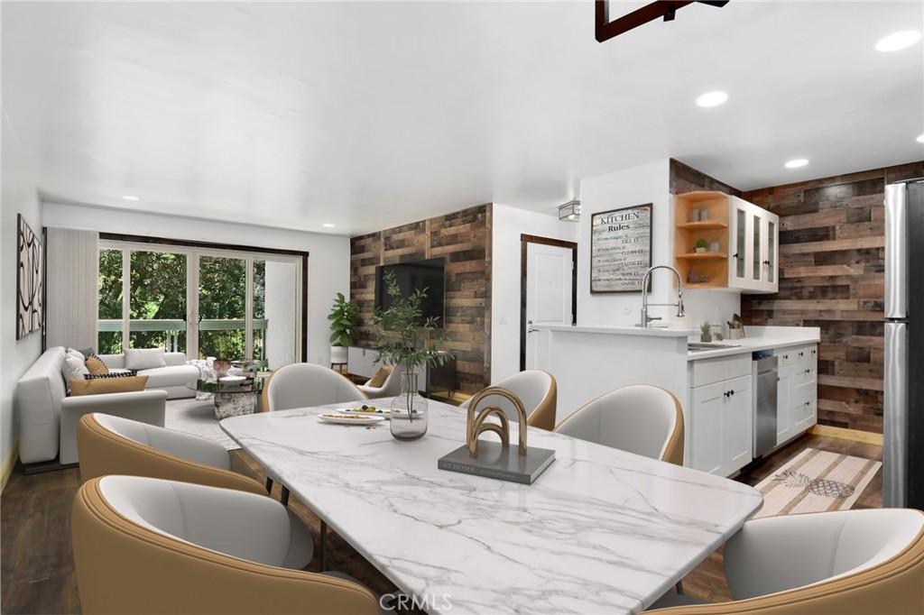 dining area featuring sink, hardwood / wood-style floors, and wood walls