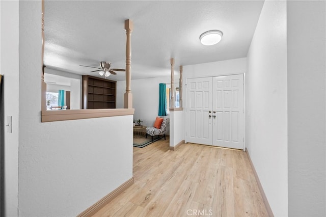 foyer entrance featuring ceiling fan, a textured ceiling, and light hardwood / wood-style flooring