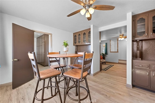 dining area with ceiling fan and light hardwood / wood-style flooring