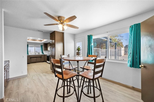 dining room with light hardwood / wood-style flooring, ceiling fan, and sink