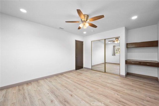 unfurnished bedroom with light hardwood / wood-style flooring, a closet, and ceiling fan