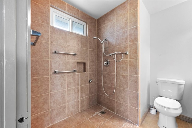 bathroom with a tile shower, tile patterned flooring, and toilet