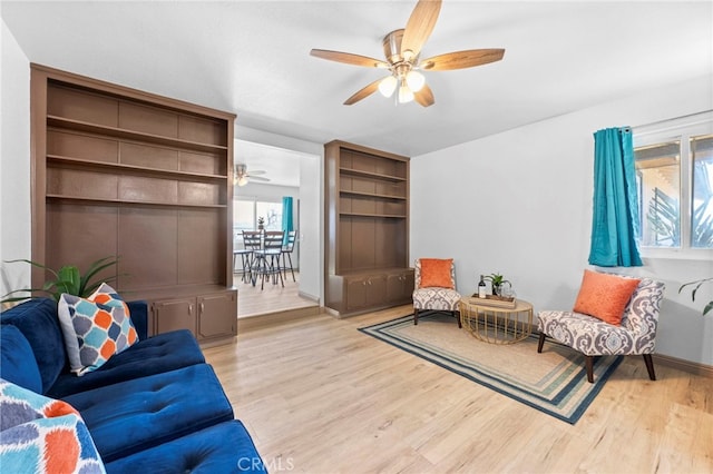 living room with light hardwood / wood-style flooring and ceiling fan