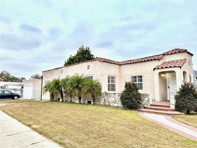 mediterranean / spanish house featuring a front yard