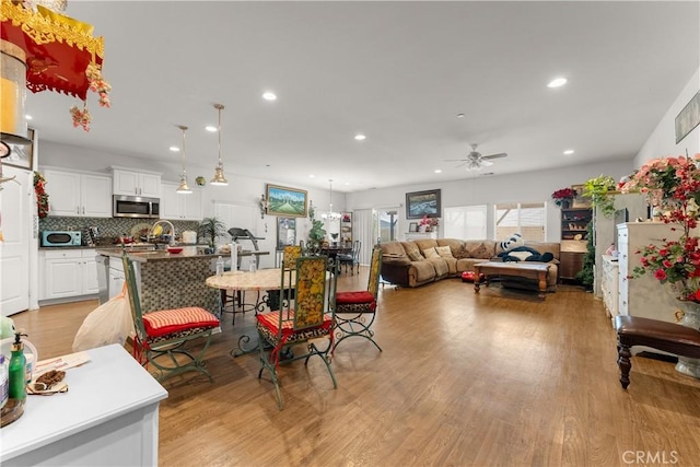 dining room with ceiling fan and light wood-type flooring