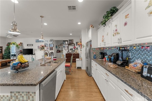 kitchen featuring sink, stainless steel appliances, light hardwood / wood-style flooring, an island with sink, and white cabinets