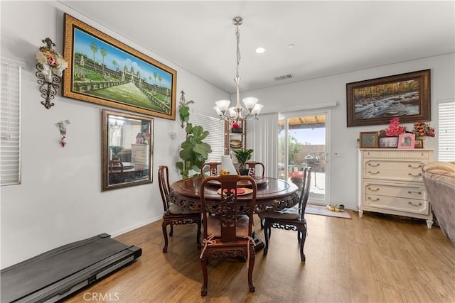 dining space featuring light hardwood / wood-style floors and a chandelier