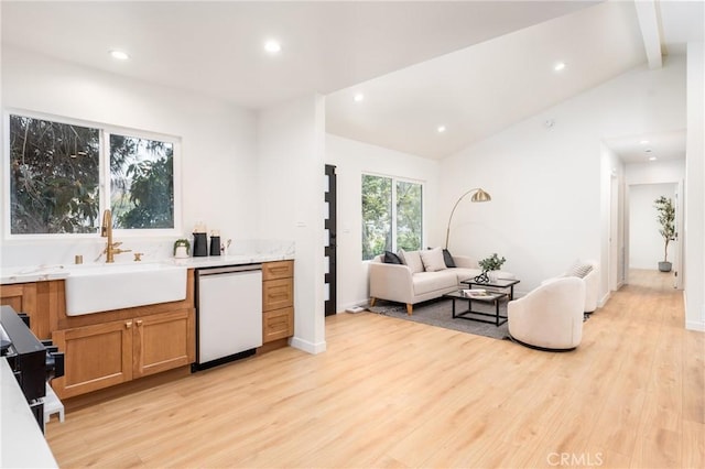 kitchen featuring dishwasher, lofted ceiling with beams, sink, and light hardwood / wood-style flooring