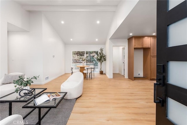 living room with beam ceiling, high vaulted ceiling, and light hardwood / wood-style flooring