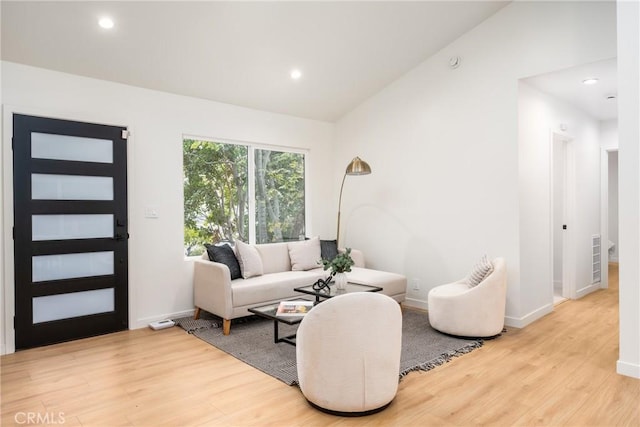 living room with vaulted ceiling and light hardwood / wood-style flooring