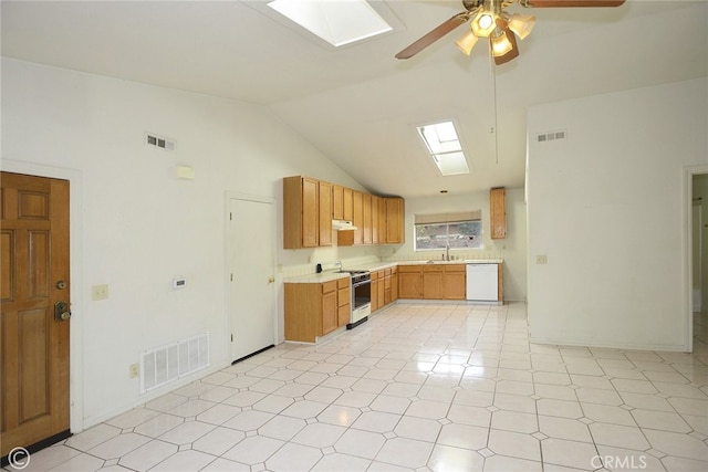 kitchen featuring dishwasher, range with gas stovetop, sink, ceiling fan, and lofted ceiling with skylight